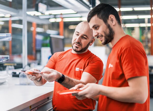 Zwei Mitarbeitende der IGP Pulvertechnik AG unterhalten sich über Pulverlacke | © IGP Pulvertechnik AG